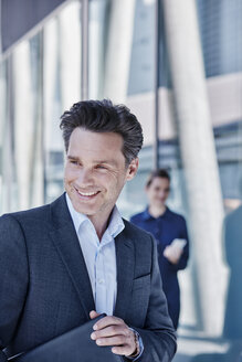 Portrait of smiling businessman with briefcase - RORF00996