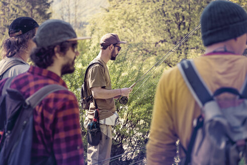 Slovenia, four men preparing for fly fishing in Soca river - BMAF00334