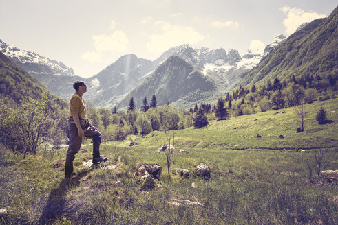 Slovenia, Bovec, man standing on meadow near Soca river - BMAF00339