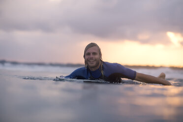 Indonesien, Bali, Surfer im Meer bei Sonnenaufgang - KNTF00873