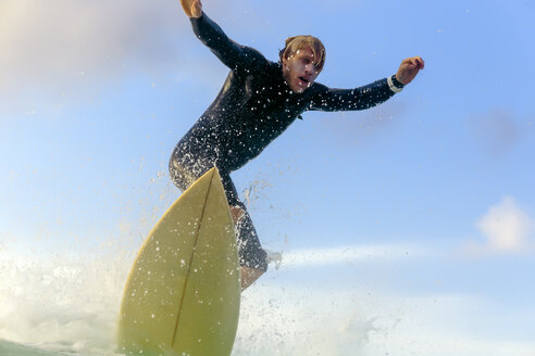 Indonesien, Bali, Surfer auf einer Welle - KNTF00877