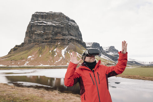 Iceland, man wearing Virtual Reality Glasses in nature - RAEF01902