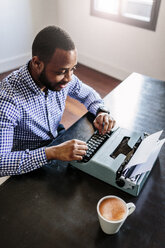 Young man at desk using typewriter - GIOF03134