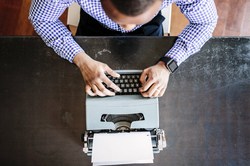 Junger Mann am Schreibtisch mit Schreibmaschine - GIOF03136