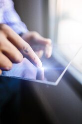 Close-up of man using a futuristic tablet - GIOF03154