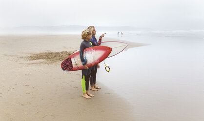 Spanien, Aviles, zwei junge Surfer am Strand - MGOF03548