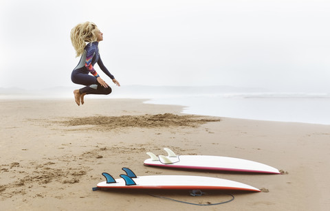 Spanien, Aviles, junger Surfer beim Aufwärmen vor dem Surfen, lizenzfreies Stockfoto