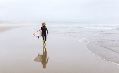 Spanien, Aviles, junger Surfer mit Surfbrett am Strand - MGOF03562