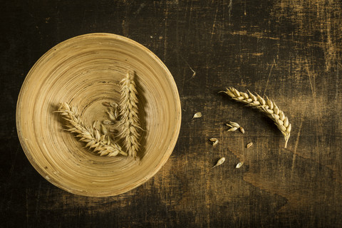 Weizenähren und Körner auf Holzschale und Holz, lizenzfreies Stockfoto