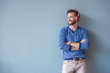 Smiling man listening to music with headphones - DIGF02716