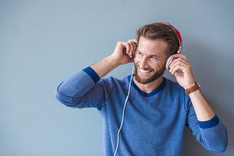 Smiling man listening to music with headphones stock photo