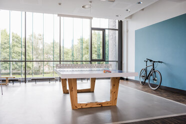 Table tennis table and bicycle in break room of modern office - DIGF02738