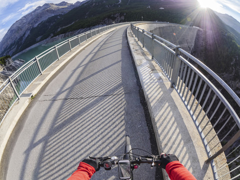 Italien, Lombardei, Sondrio, Radfahrer auf der Staumauer der Cancano-Talsperre, lizenzfreies Stockfoto