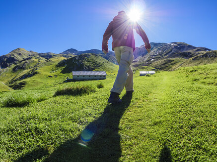 Italien, Lombardei, Sondrio, Wanderer auf Almwiese auf dem Weg zum Umbrailpass - LAF01878