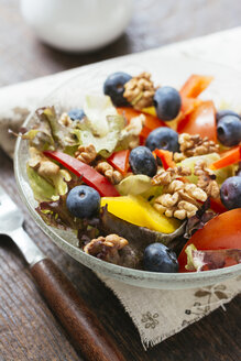 Glasschüssel mit gemischtem Salat mit verschiedenen Rohkostsorten, Blaubeeren und Walnüssen - HAWF00963