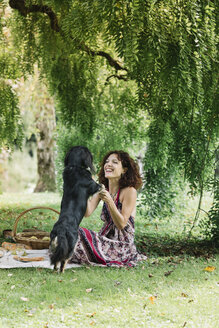 Woman with dog having a picnic in a park - ALBF00154