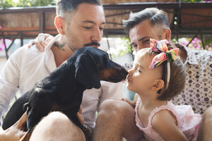 Gay couple with daughter and dog on balcony - MRAF00224