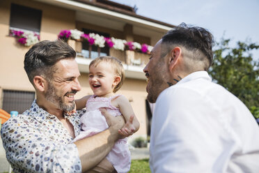 Happy gay couple with their child in the garden - MRAF00232