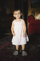 Portrait of baby girl wearing oversized shoes at home - MRAF00249