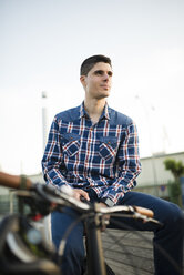 Young man with bicycle outdoors - RAEF01928