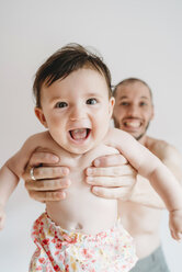 Porträt eines lachenden kleinen Mädchens, das von seinem Vater gehalten wird - GEMF01770