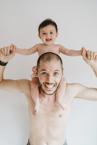 Porträt eines Vaters, der seine kleine Tochter auf den Schultern trägt, lizenzfreies Stockfoto