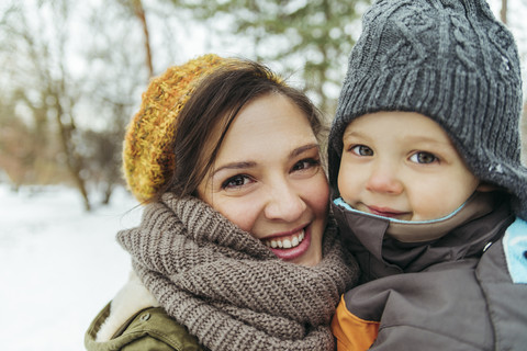 Porträt von Mutter und kleinem Sohn im Schnee, lizenzfreies Stockfoto