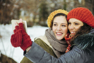 Two friends taking selfies in the snow - ZEDF00809