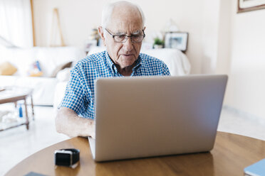 Porträt eines älteren Mannes, der zu Hause lernt, einen Laptop zu benutzen - JRFF01412