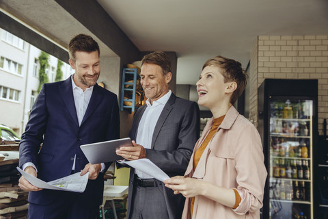 Woman and two businessmen discussing plans in a cafe stock photo