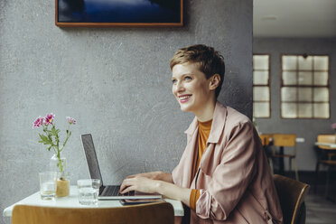 Frau arbeitet in einem Café mit ihrem Laptop - MFF03822