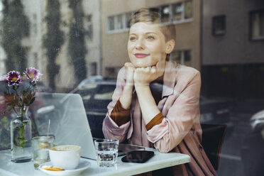 Frau mit ihrem Laptop genießt die Aussicht in einem Cafe - MFF03828