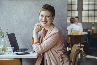 Portrait of smiling woman in cafe with laptop - MFF03830