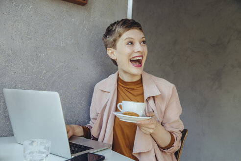 Überrascht Frau mit ihrem Laptop genießen eine Tasse Kaffee in einem Café - MFF03831