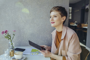 Frau mit einem Tablet in einem Café mit Blick zur Seite - MFF03835