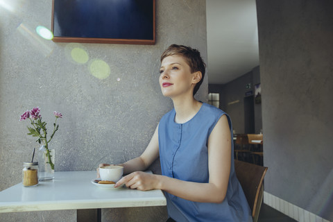 Frau mit einer Tasse Kaffee in einem Kaffeehaus, lizenzfreies Stockfoto