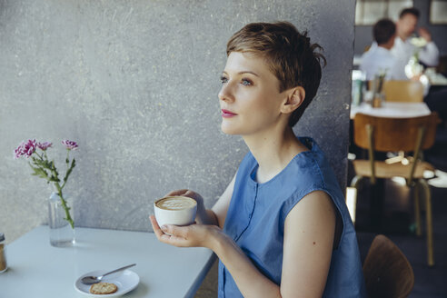 Ernste Frau mit einer Tasse Kaffee in einem Cafe - MFF03842