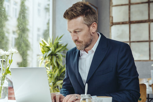 Geschäftsmann arbeitet in einem Café mit Laptop - MFF03859