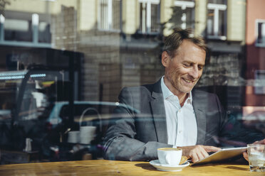 Businessman using tablet in cafe - MFF03867