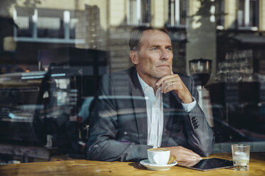 Serious businessman in cafe looking out of window - MFF03869