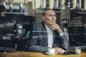 Ernster Geschäftsmann im Café, der aus dem Fenster schaut - MFF03869