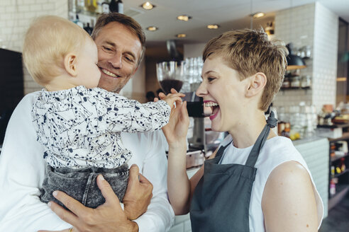 Kellnerin spielt mit dem Baby eines Kunden im Cafe - MFF03880