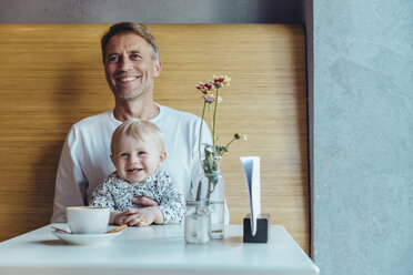 Glücklicher reifer Vater und Sohn sitzen in einem Cafe - MFF03882