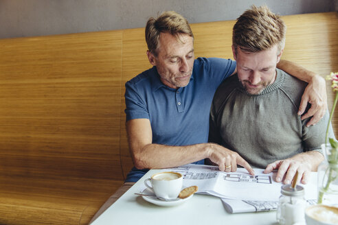 Homosexuelles Paar sieht sich Baupläne für sein Haus im Cafe an - MFF03893