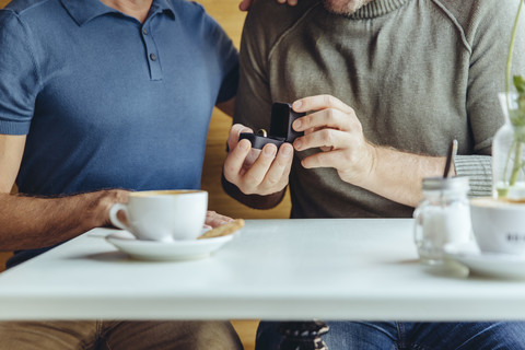 Nahaufnahme eines schwulen Paares mit Ehering in einem Cafe, lizenzfreies Stockfoto