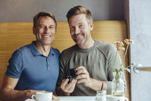 Porträt eines schwulen Paares mit Ehering in einem Cafe - MFF03898