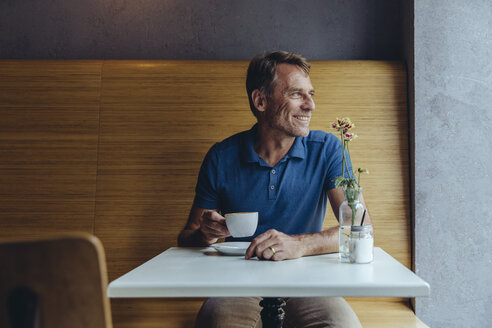 Lächelnder reifer Mann sitzt in einem Cafe - MFF03907