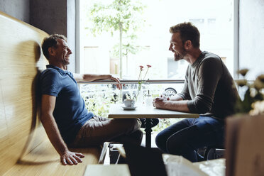 Zwei Männer sitzen in einem Café und reden miteinander - MFF03908