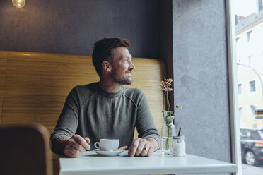 Smiling mature man sitting in cafe looking out of window - MFF03910