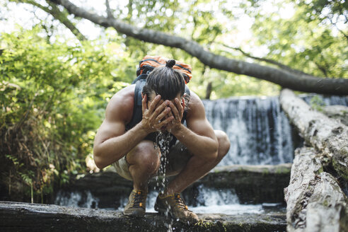 Junger Mann auf einer Wanderung erfrischt sich an einem Wasserfall - VPIF00025